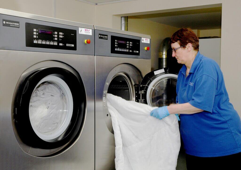 Whitby Court Care Home Employee using the commercial laundry equipment.